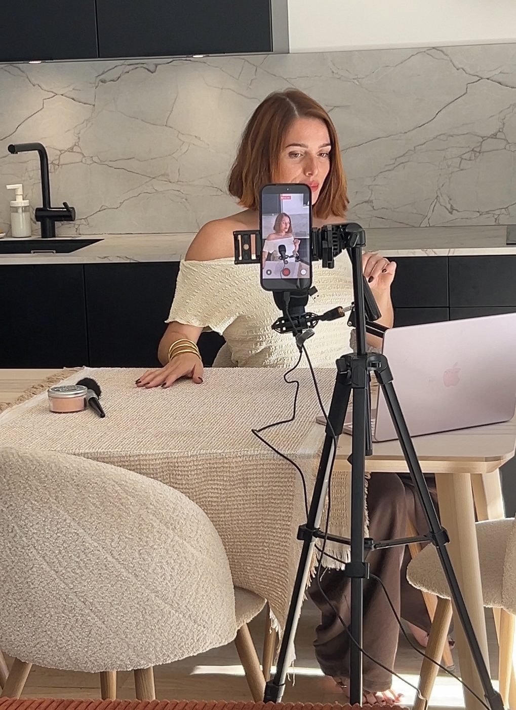 Kathleen, créatrice UGC, se filme avec son téléphone posé sur un trépied
